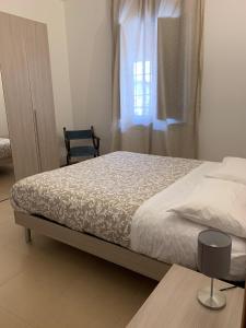 um quarto com uma cama, uma cadeira e uma janela em La Casetta Rosa em Travacò Siccomario