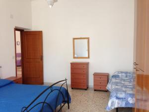 a bedroom with a bed and a dresser and a mirror at Casa Vacanze in Santa Maria di Castellabate
