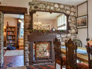 a living room with a stone fireplace and a mirror at The Resting Dragon in Ystalyfera