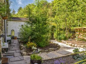 a garden with a stone path and a tree at The Resting Dragon in Ystalyfera