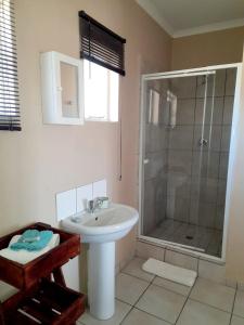 Weaver's Nest Country Inn في Wakkerstroom: حمام مع حوض ودش +36 صورة