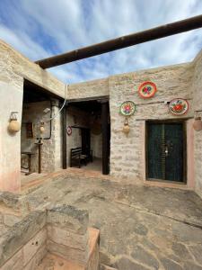 einen Außenblick auf ein Steinhaus mit einer Terrasse in der Unterkunft نزل كوفان التراثي Koofan Heritage Lodge in Salalah