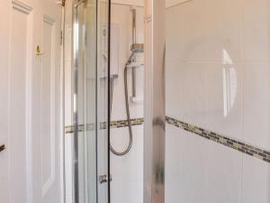 een badkamer met een douche en een glazen deur bij Fell Mount in Grange Over Sands
