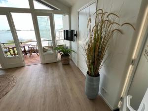 a hallway with potted plants and a view of the ocean at Plassenzicht Logies & Sloepverhuur in Loosdrecht