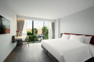 een slaapkamer met een groot wit bed en een bureau bij Centara Life Hotel Bangkok Phra Nakhon in Bangkok