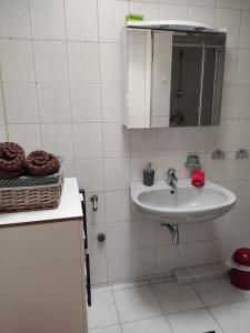 a white bathroom with a sink and a mirror at Stubnitz in Hagen