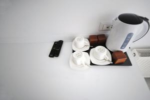 Hotel Callisto في بريشتيني: طاولة مع آلة صنع القهوة وريموت كنترول