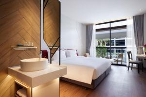 een hotelkamer met een groot bed en een wastafel bij Centara Life Hotel Bangkok Phra Nakhon in Bangkok