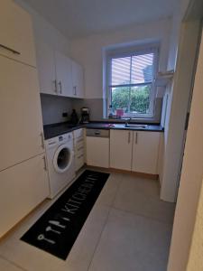 a kitchen with a washing machine and a window at Renovierte Ferienwohnung in Nienburg Erichshagen in Erichshagen