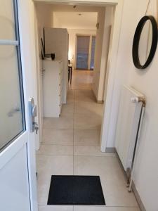 a hallway with a door and a mirror and a tile floor at Renovierte Ferienwohnung in Nienburg Erichshagen in Erichshagen