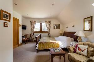 a hotel room with a bed and a couch at Dalmunach House in Aberlour