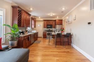 a kitchen with wooden cabinets and a kitchen island with bar stools at 90-Boston Spacious Convenient Apartment in Boston
