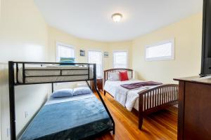 a bedroom with two bunk beds and a tv at 90-Boston Spacious Convenient Apartment in Boston