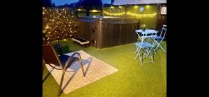 um quintal com uma mesa, cadeiras e luzes em Wee Hoose-Private-Hottub -Romantic Break-Portaferry 
