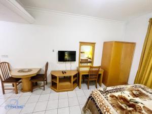 Schlafzimmer mit einem Bett, einem Tisch und einem Schreibtisch in der Unterkunft Delmon Suites in Amman