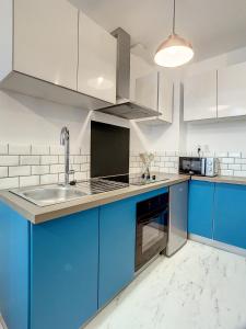 a kitchen with blue cabinets and a sink at Appartement de charme: La rochelle/vieux port in La Rochelle