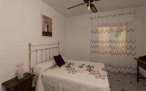 a white bedroom with a bed and a window at Precioso piso de 3 dormitorios, cocina y 1 baño in Cómpeta