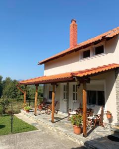 a house with a patio with chairs and tables at Guesthouse Anestis in Angistron