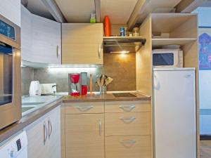 a kitchen with wooden cabinets and a white refrigerator at Chalet cosy avec garage et vues, 3 niveaux, 6 pers, proche Luz, animaux admis - FR-1-402-54 in Viella