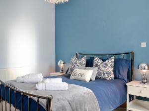 a blue bedroom with a bed with blue walls at Eleanor Cottage in Ballater