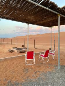 two chairs sitting under a tent in the desert at Panorama Camp Bidiya in Al Wāşil