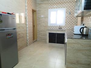 a kitchen with a refrigerator and a counter top at Grand Orchid Hotel Apartment in Duqm +20 photos
