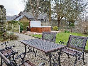 una mesa de picnic y dos sillas en un patio en Ty Bach Twt, en Dyffryn
