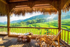 Pu Luong的住宿－Puluong Luna Resort，一个带椅子和桌子的门廊,享有美景