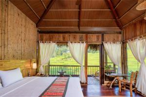 a bedroom with a bed and a balcony at Puluong Luna Resort in Pu Luong