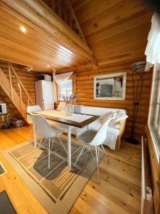 a dining room with a table and chairs in a cabin at Villa Konnekoski, pearl front of Etelä-Konnevesi National park in Rautalampi
