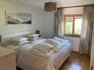 a bedroom with two beds with pillows and a window at Ferienwohnung Schwarzindien in Mondsee