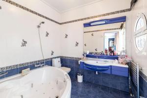 La salle de bains bleue et blanche est pourvue d'une baignoire et d'un lavabo. dans l'établissement Villa Serenity a luxury 7 bed villa at Kymi Evia, à Paralía Kímis