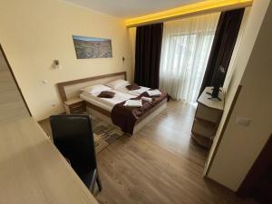 a hotel room with a bed and a television at Pensiunea Andres in Sovata