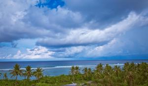 een uitzicht op een strand met palmbomen en de oceaan bij PINE LODGE MALDIVES in Hulhumale