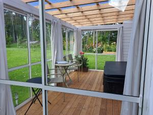 a screened in porch with a table and chairs at Myntloftet Borlänge med inglasad bubbelbad in Borlänge
