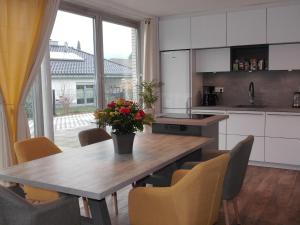 een keuken met een houten tafel met stoelen en een groot raam bij Smart Loft in Bad Pyrmont