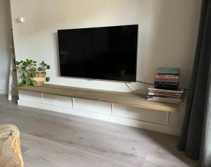 a flat screen tv on a wall in a living room at Sous aan Zee in Noordwijk