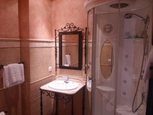 a bathroom with a sink and a shower with a mirror at Rural Vega de Cazalla in Cazalla de la Sierra +10 photos