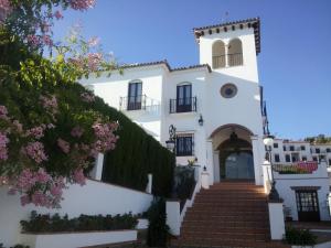 a white house with stairs and flowers at Rural Vega de Cazalla in Cazalla de la Sierra