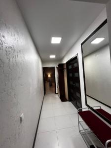 a hallway with a mirror and a chair in a room at Sky the Apartment Centre in Tiraspol