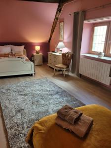 1 dormitorio con paredes rosas, 1 cama y escritorio en Les terrasses du Zinnkoepflé (8 à 12 personnes), en Westhalten