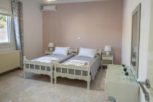 a bedroom with two beds and a mirror at Vigere Luxury Villa in Monolithos