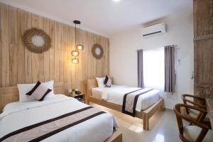 una camera d'albergo con due letti e una finestra di Oki Taru Residence a Kuta