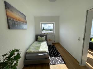 Kleines Zimmer mit einem Bett und einem Fenster in der Unterkunft Haus Weitblick Lia in Flensburg