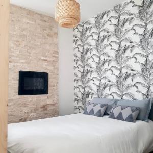 um quarto com uma cama branca e uma parede em Studio calme-équipements haut de gamme em Sarreguemines