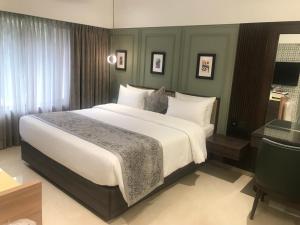 1 dormitorio con 1 cama grande con sábanas blancas en The International by Tunga en Bombay