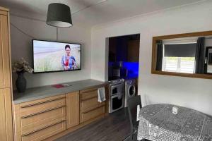 a living room with a flat screen tv on the wall at Cayton village hide away in Cayton