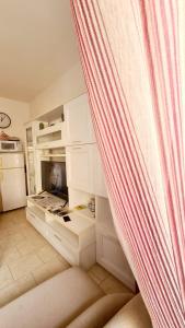 uma cozinha com armários brancos e uma cortina em Pisa City Home B&B em Pisa