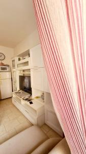 a kitchen with white cabinets and a curtain at Pisa City Home in Pisa