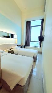 a hotel room with three beds and a window at Winland 800 Hotel - Formerly Mexan Harbour Hotel in Hong Kong